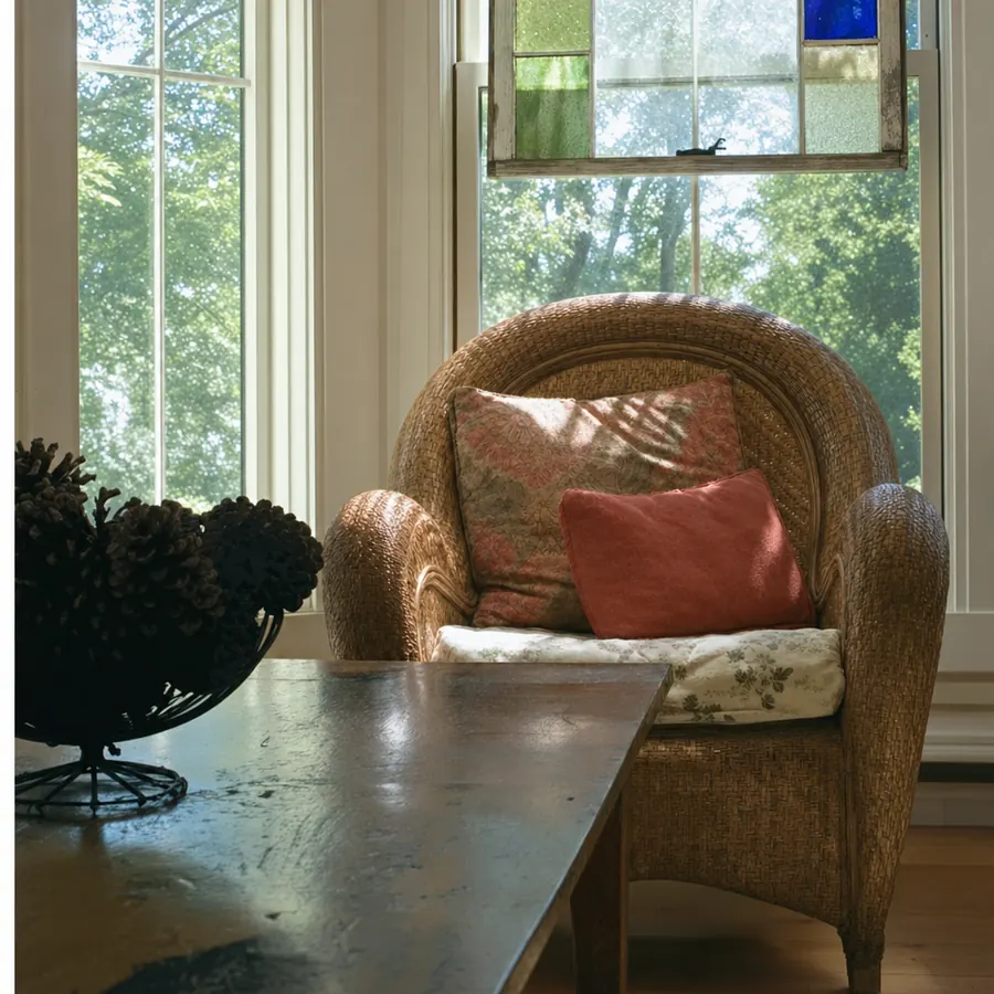 A wicker chair by a stained glass window at the Applewood Inn